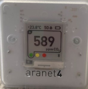 aranet4 device showing a reading of 589 ppm. The bottom of the screen shows three dots in red yellow and blue, and the CO2 reading is highlighted by a frame
